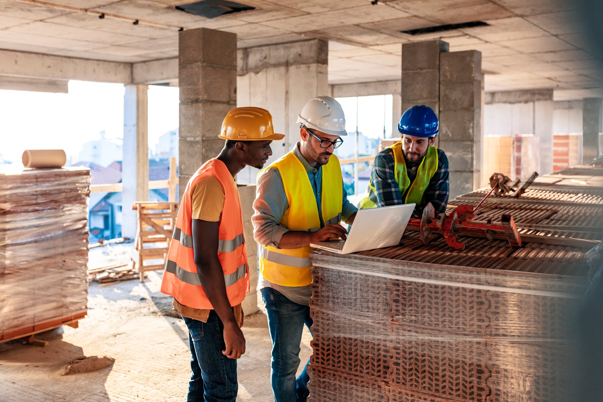 construction workers looking at laptop construction workers looking at laptop