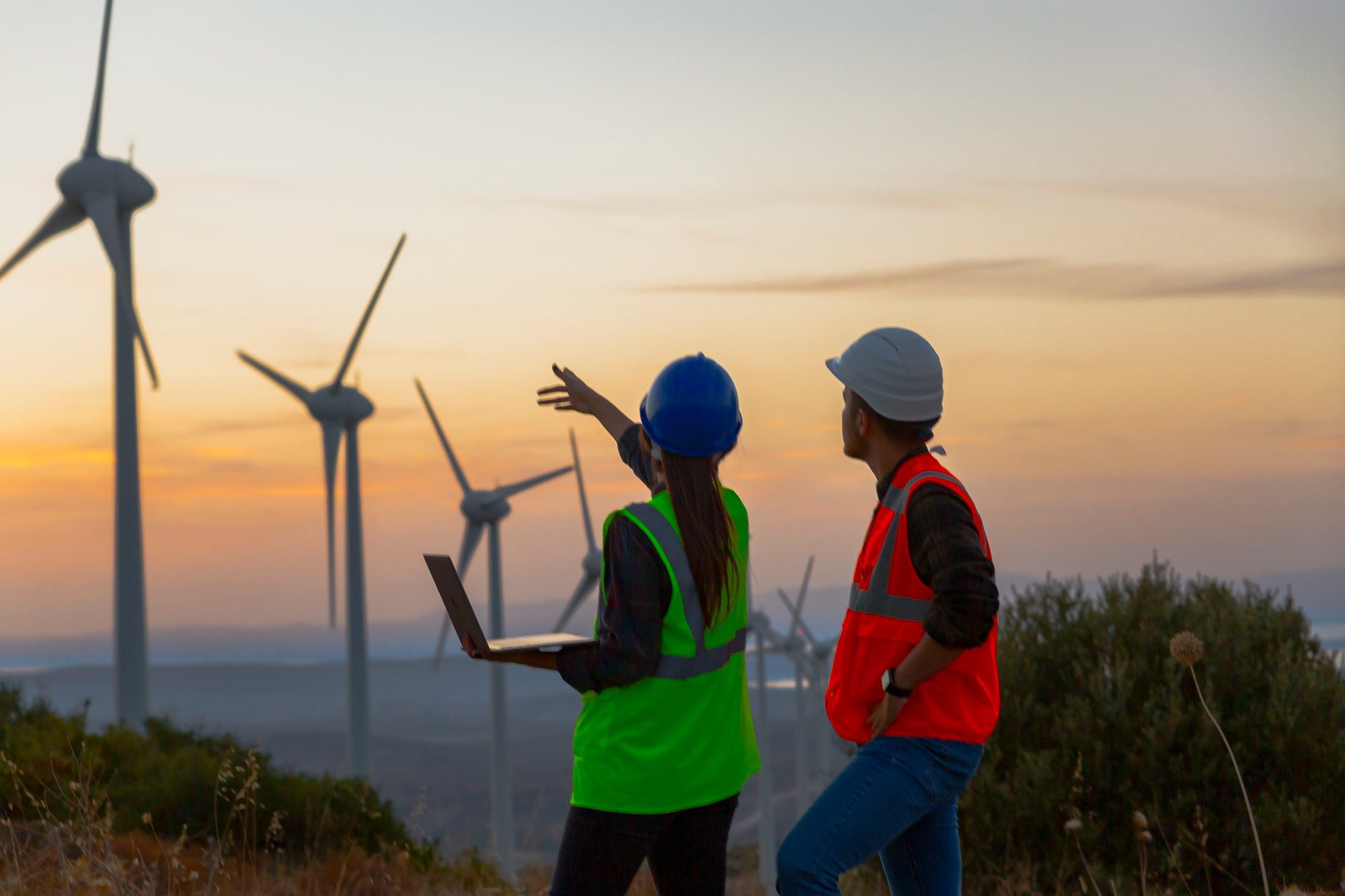 male and female engineers inspecting wind turbines male and female engineers inspecting wind turbines